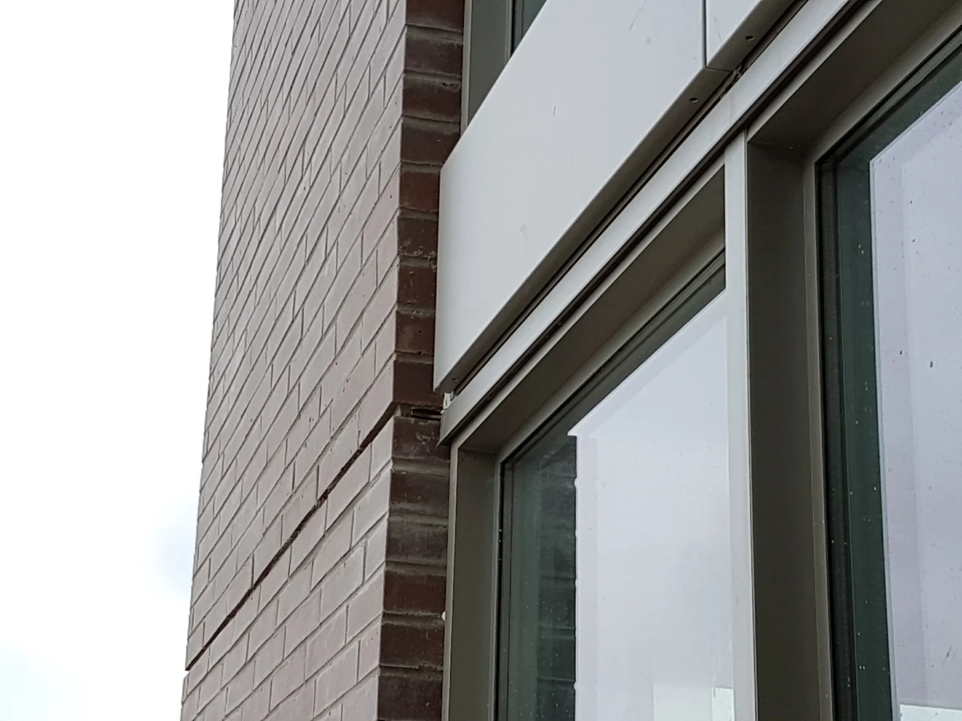 Window head and perimeter junction with adjacent brick masonry